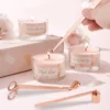 Rose gold candle accessory set with wick trimmer, dipper, and snuffer on white background